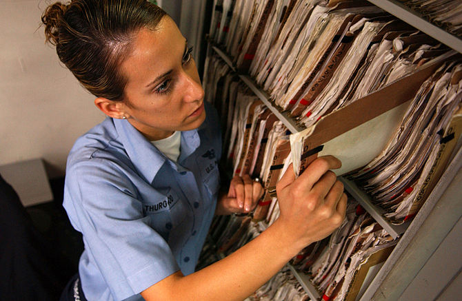 A medical record folder being pulled from the ...