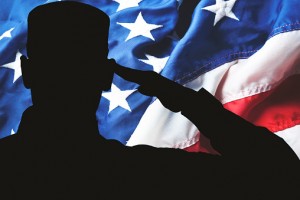 Proud saluting male army soldier on american flag background