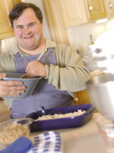Man With Down Syndrome Smiling While Making A Cake
