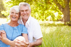 Senior couple sitting on grass together relaxing